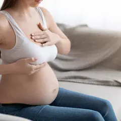 Kobieta w ciąży, dotykająca swoich piersi. Sutki w ciąży stają się większe i wrażliwsze.