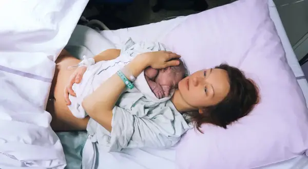 Mama tuli nowo narodzone dziecko na piersi. To piękny moment kangurowania, budowania więzi i bliskości po porodzie.