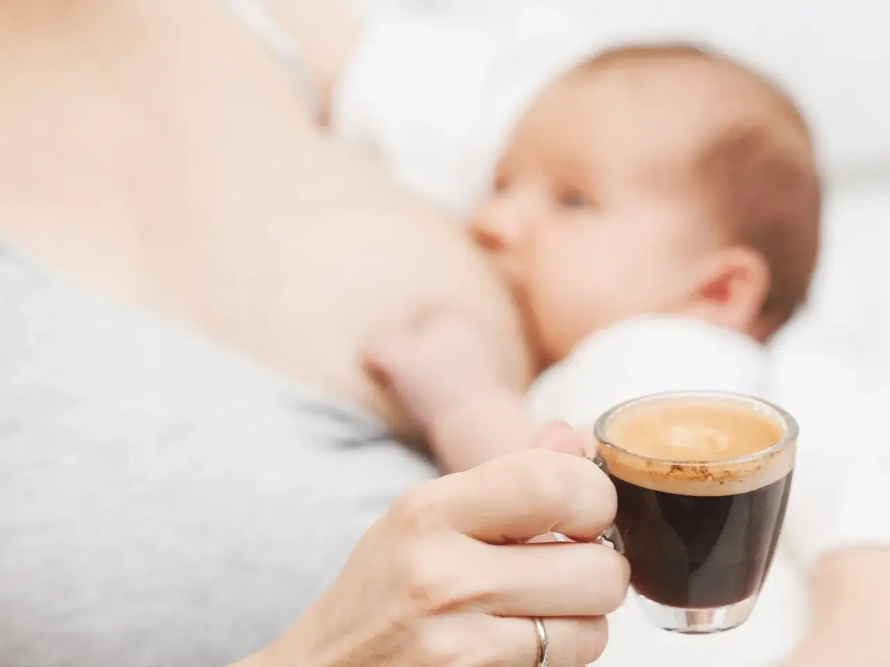 Chwila spokoju podczas karmienia piersią. Mama popija kawę, a maluszek je.